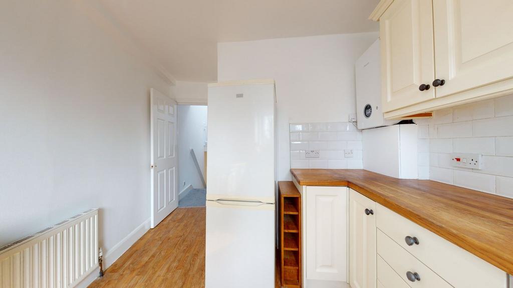 Bright and tidy kitchen featuring cream cabinet...