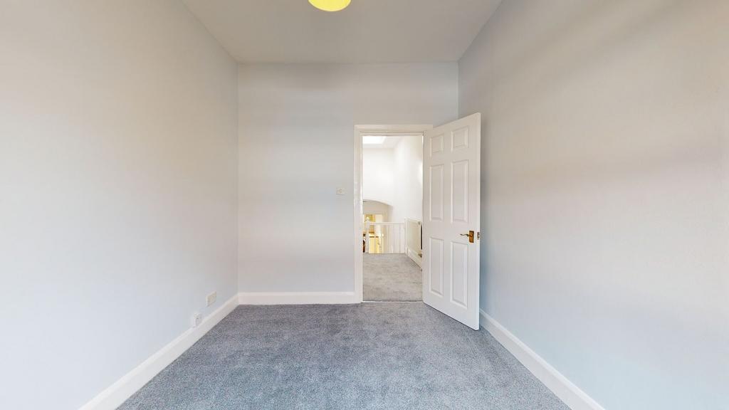 A clean and freshly carpeted single bedroom wit...