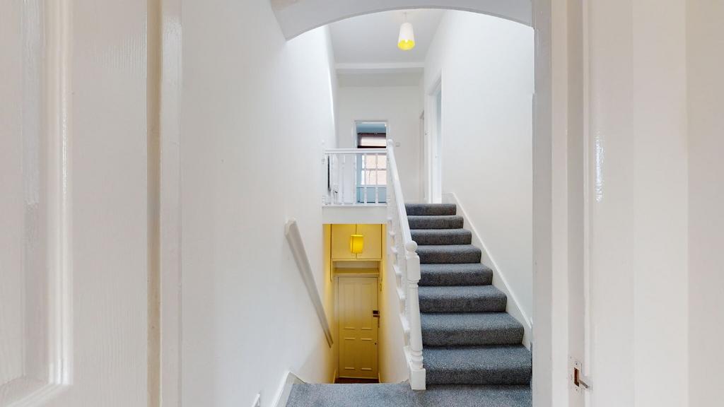 Bright and clean hallway with white walls and g...