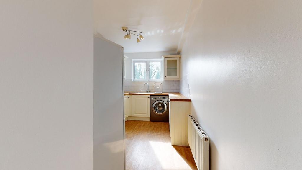 Bright and clean kitchen featuring white cabine...