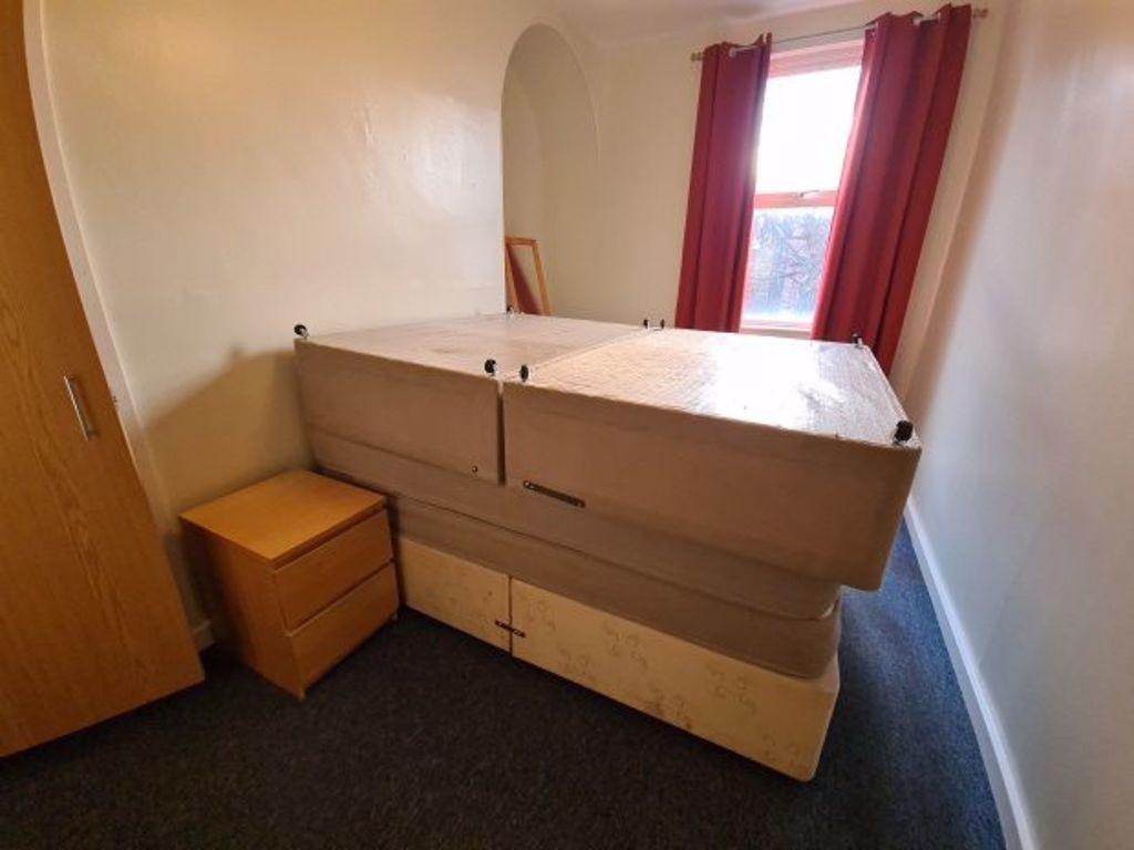 Compact furnished bedroom with a large bed, fit...