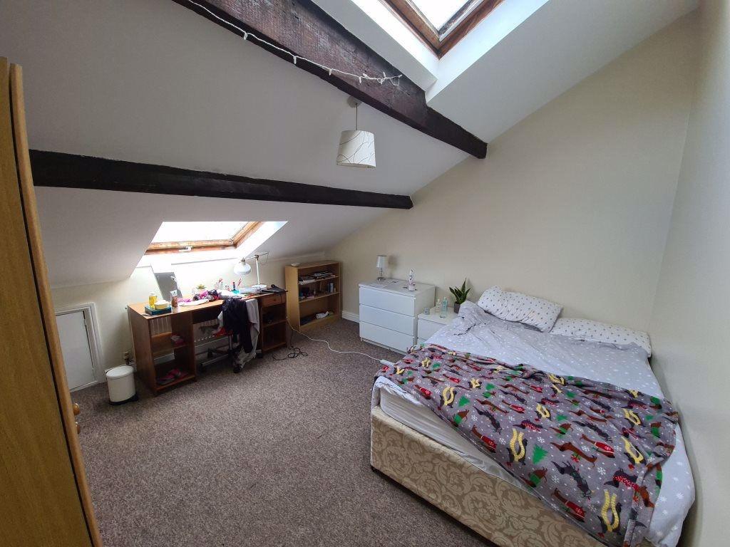 Bright attic bedroom with sloped ceilings and e...