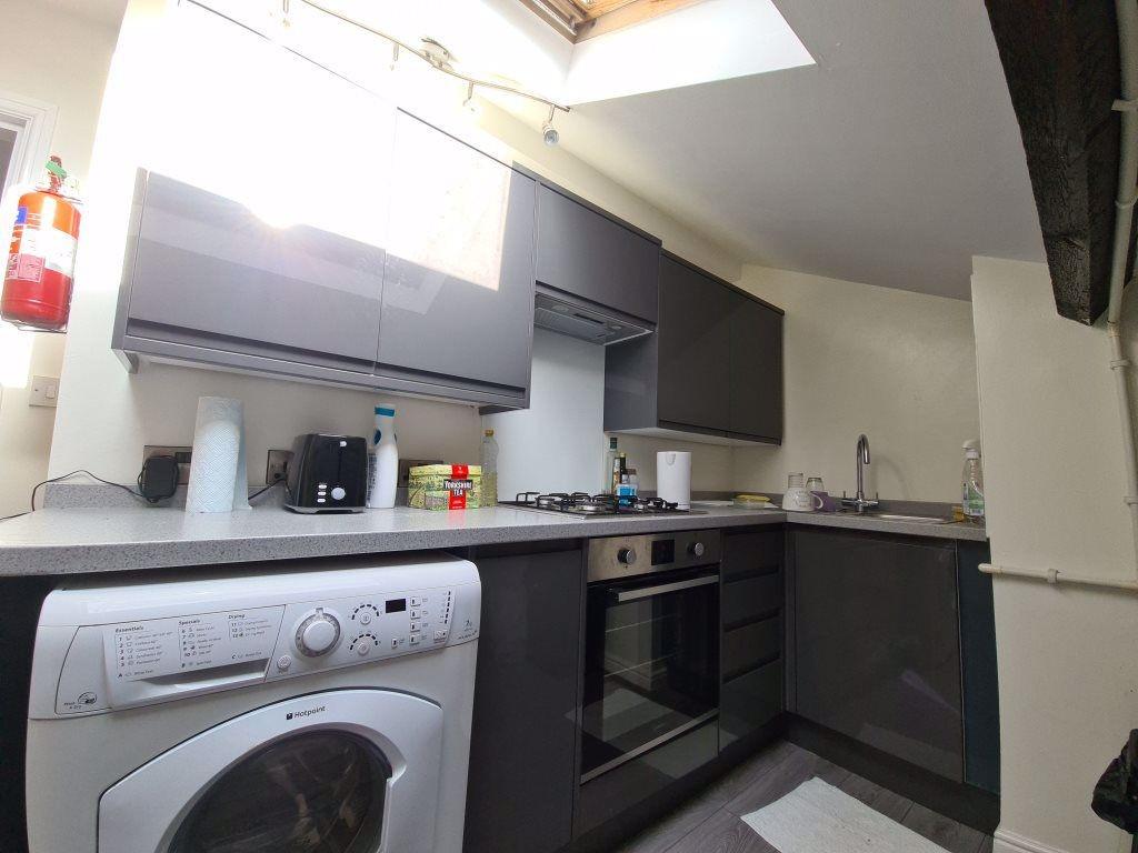 Modern fitted kitchen with integrated oven, was...