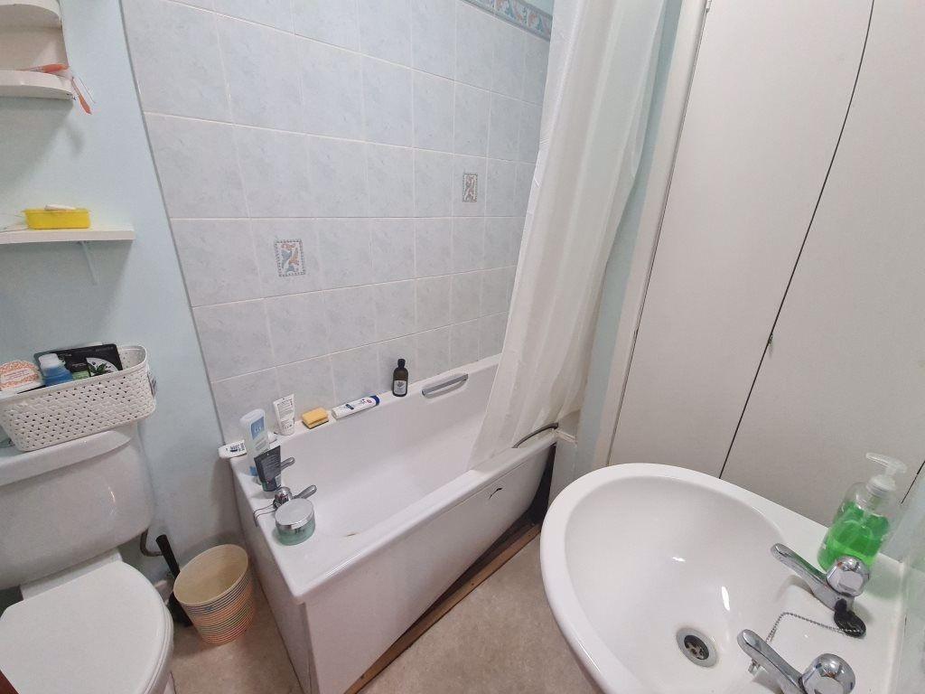 Bright, tidy bathroom with a bathtub and shower...