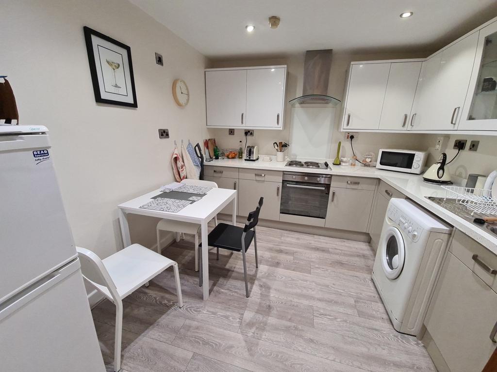 Bright, modern fitted kitchen with integrated o...