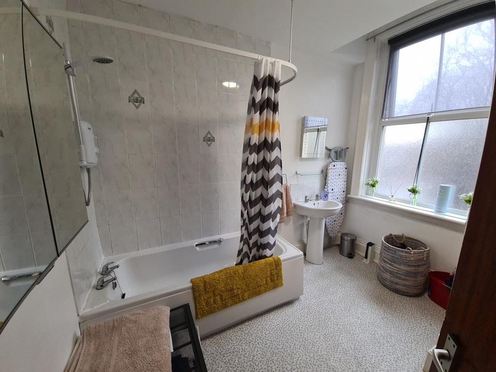 Bright, well-kept bathroom featuring a bathtub ...
