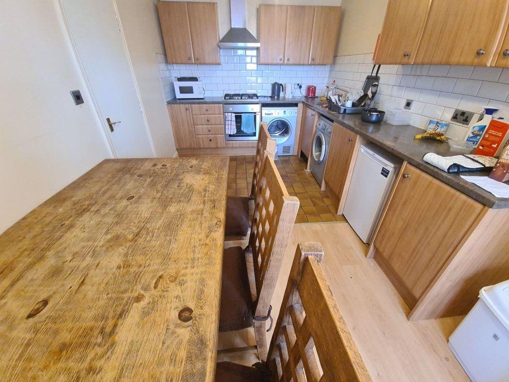 Bright shared kitchen with wooden cabinetry, a ...