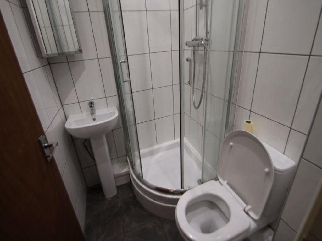 Compact, modern bathroom with a corner glass sh...