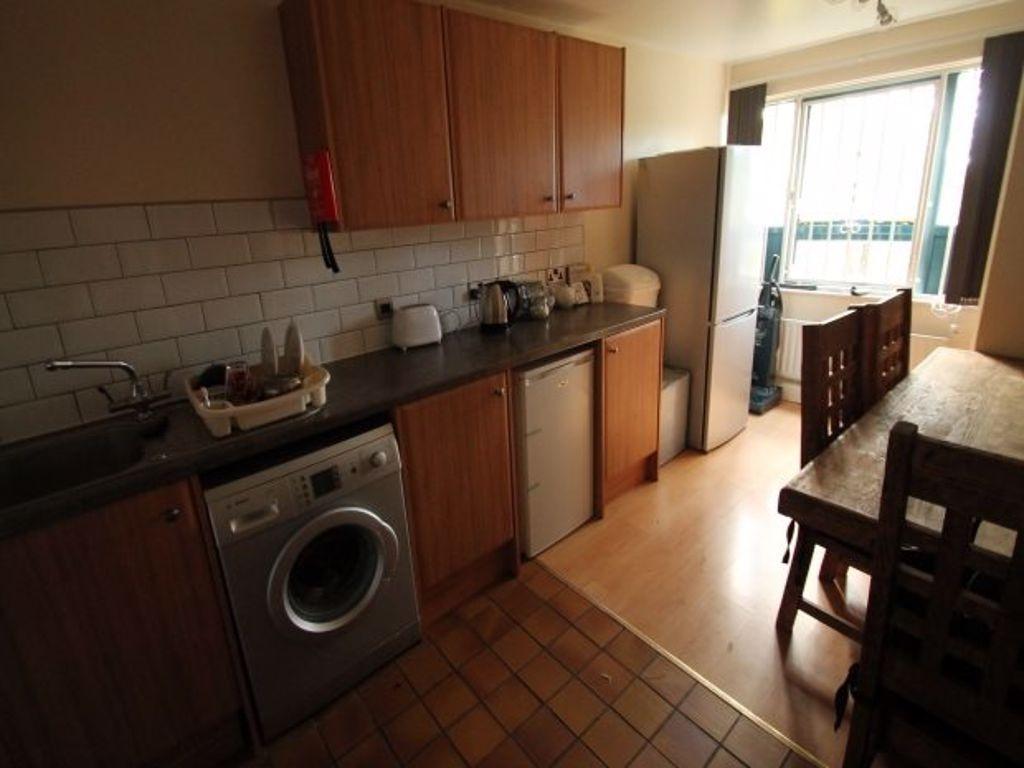 Well-equipped galley kitchen with wood-effect c...