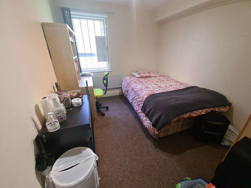 Neat, simply furnished bedroom with a comfortab...