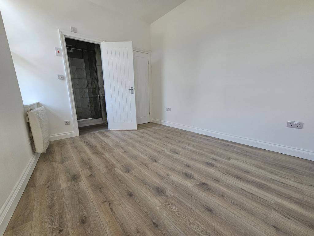 Bright, freshly painted bedroom with modern woo...