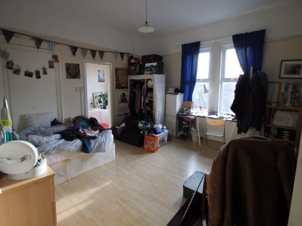 Spacious, well-lit bedroom with large window, f...