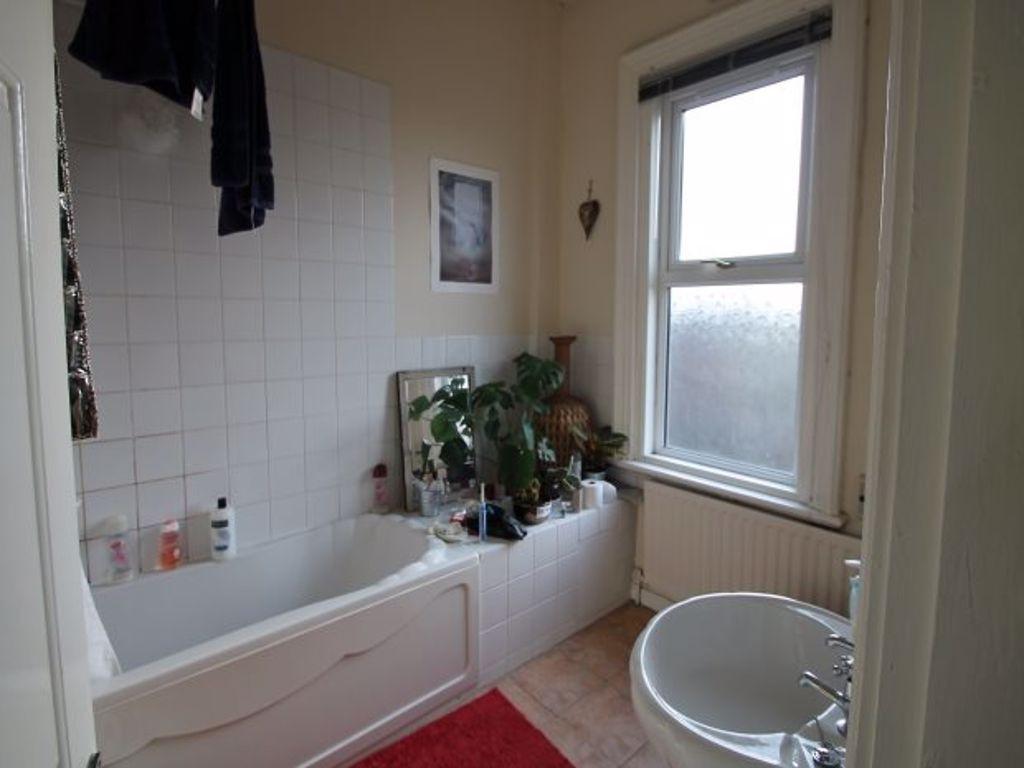 Bright bathroom with a bathtub, basin and a fro...