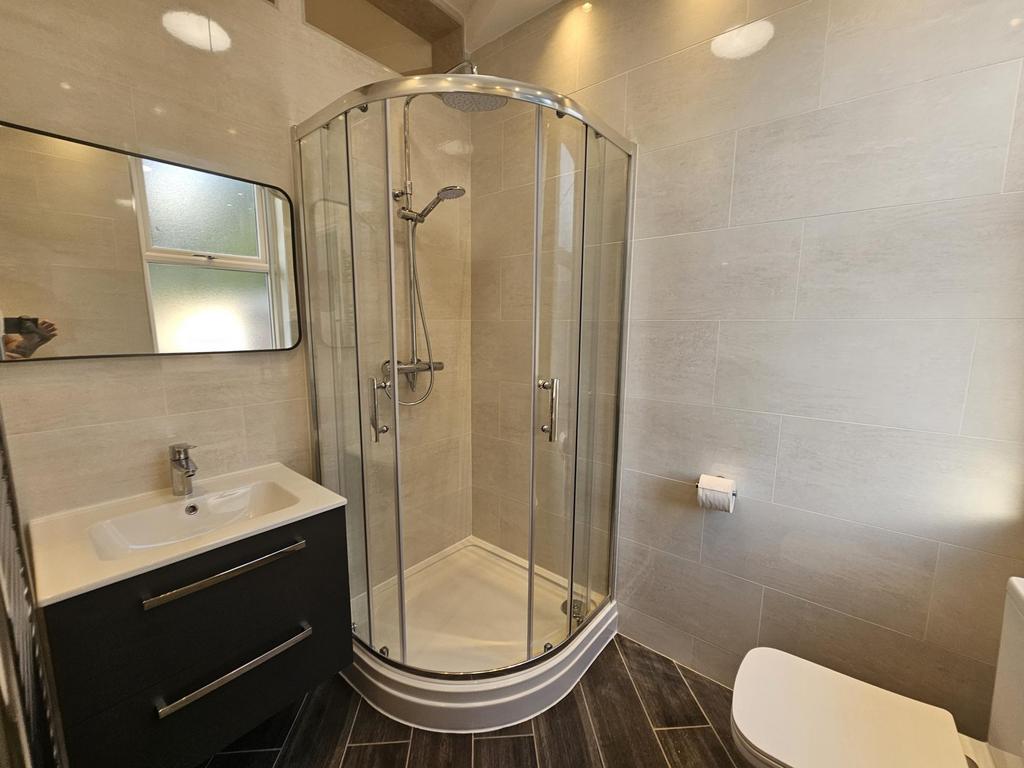 Bright, modern bathroom featuring a curved corn...