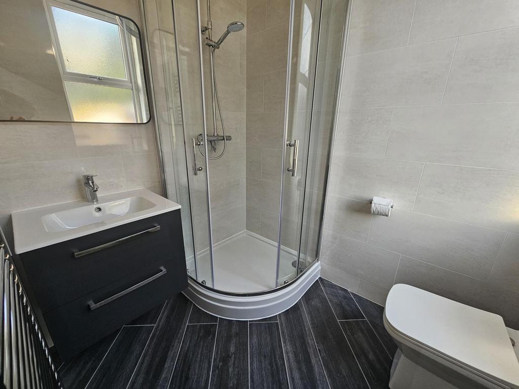 Modern bathroom with a curved glass shower encl...