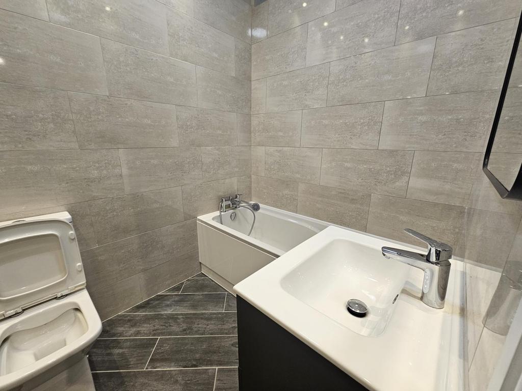 Modern bathroom with matching grey tiled walls ...