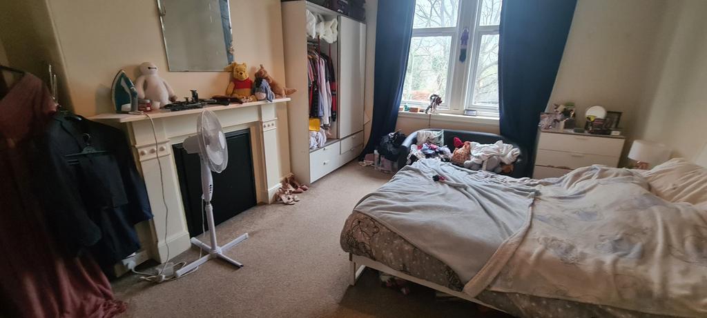 Bright double bedroom with a large window, neut...