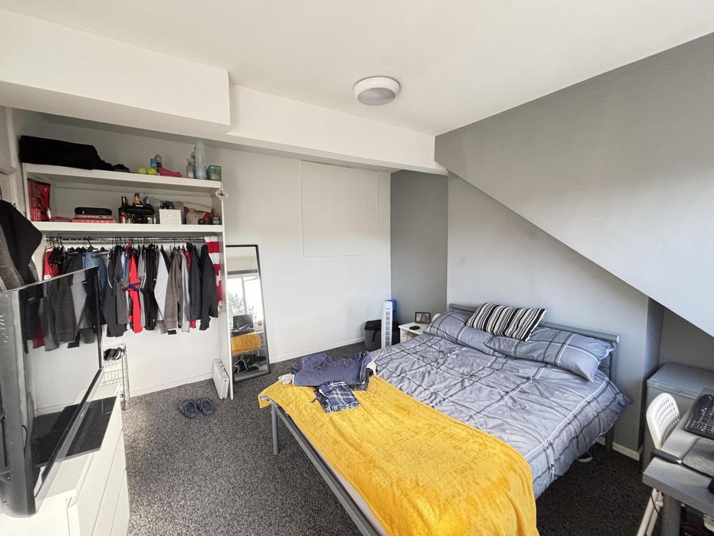 A well-lit, tidy bedroom featuring a double bed...
