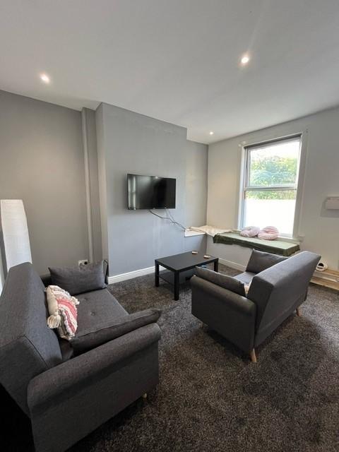 A modern, well-lit living room featuring comfor...