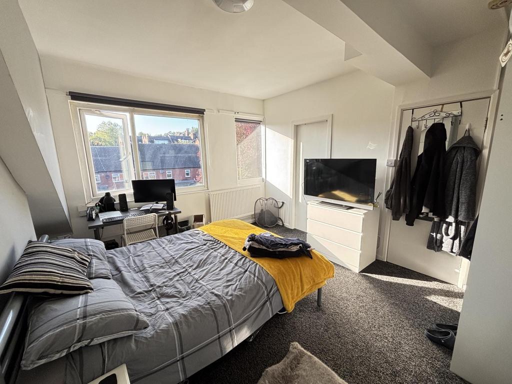 A bright, well-maintained bedroom featuring a d...