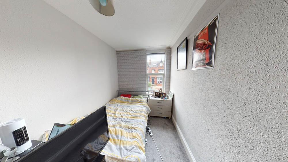 A well-lit bedroom with a window providing natu...