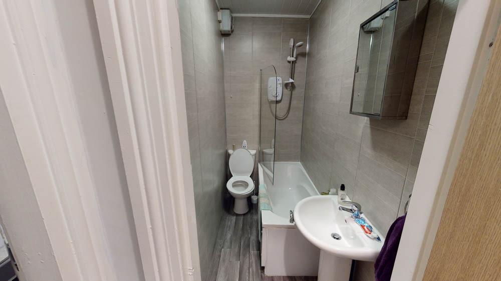 A clean and functional bathroom with a bathtub,...