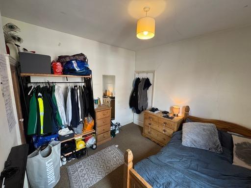 A cozy bedroom featuring a double bed, a wooden...