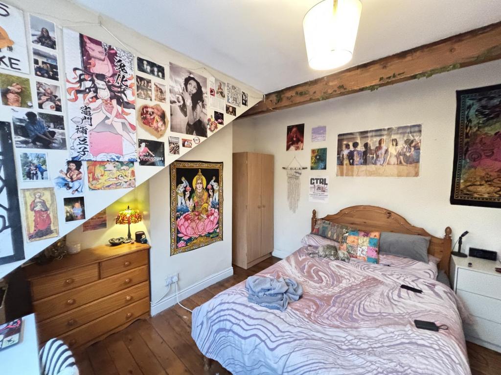 A cozy bedroom featuring a neatly made bed with...