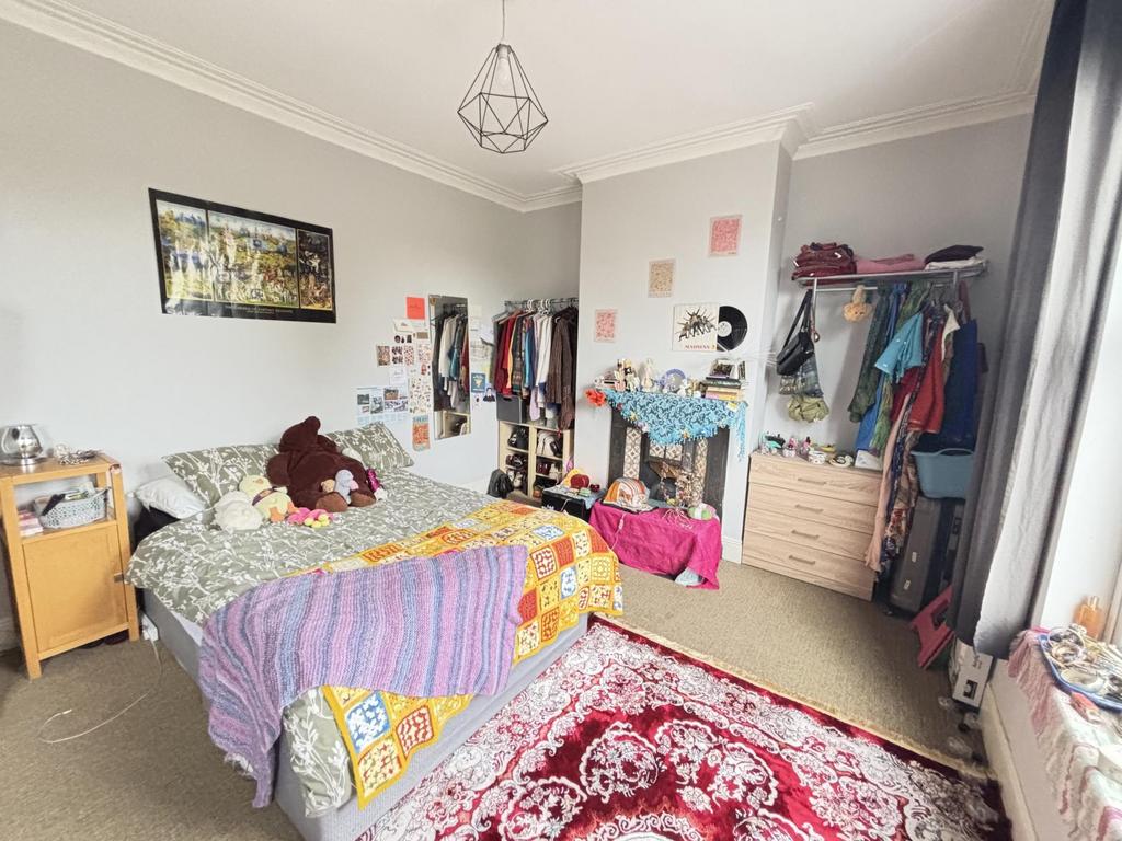 A cozy bedroom with a single bed and colorful b...