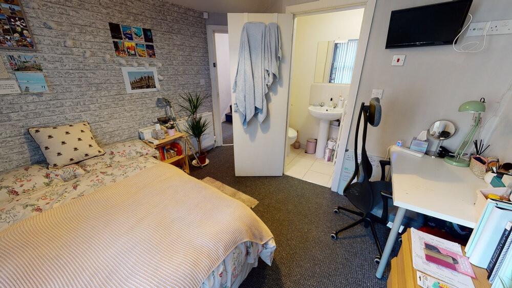 A cozy student bedroom featuring a double bed a...