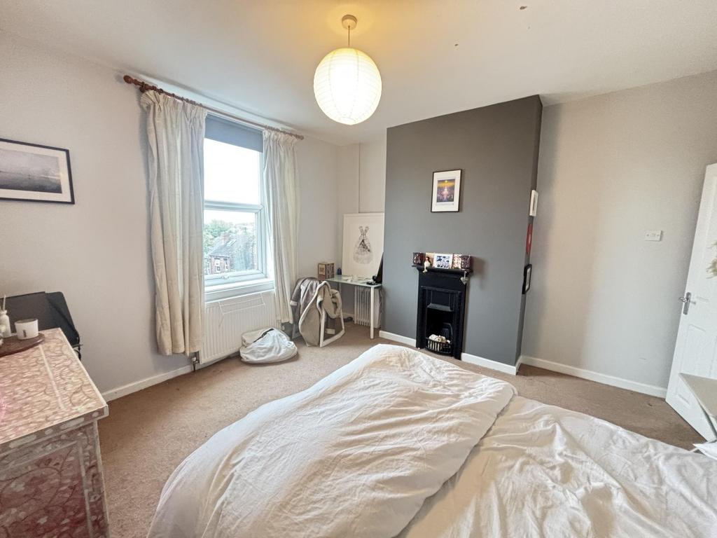 A well-lit, inviting bedroom with a comfortable...