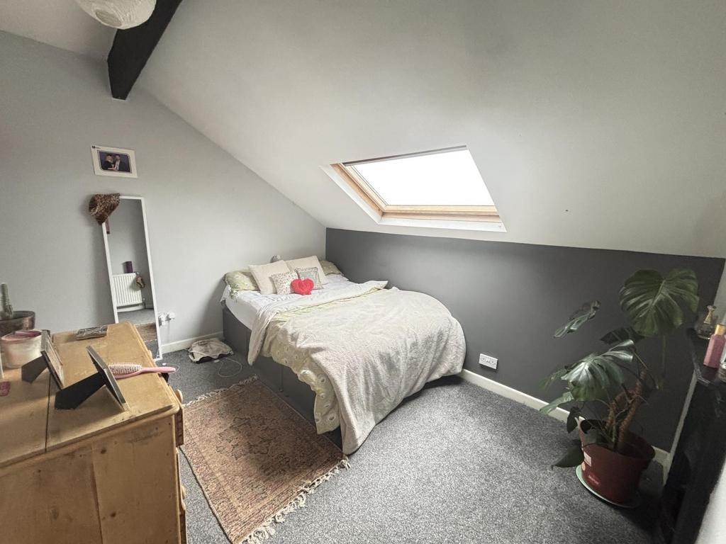 A cozy single bedroom illuminated by natural li...