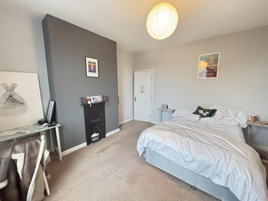 A bright and tidy bedroom featuring a comfortab...