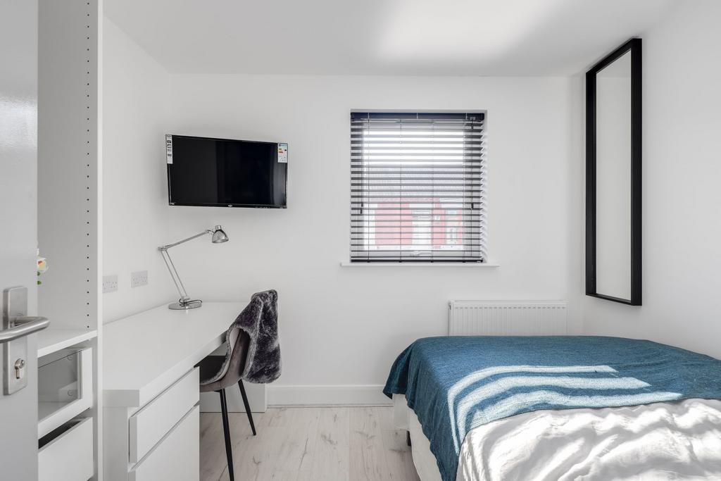 A bright and modern student bedroom featuring a...
