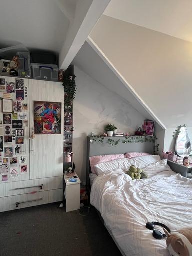 A bright and cozy bedroom featuring a large bed...