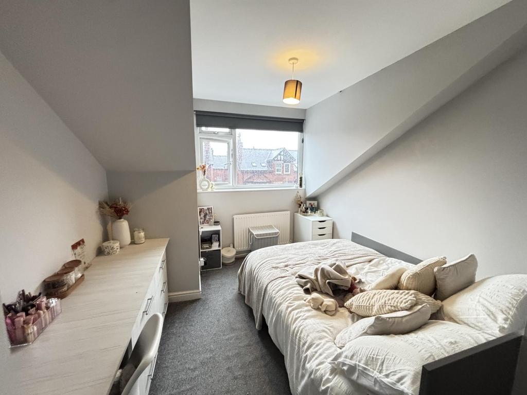 Bright, neatly styled bedroom with a comfy sing...