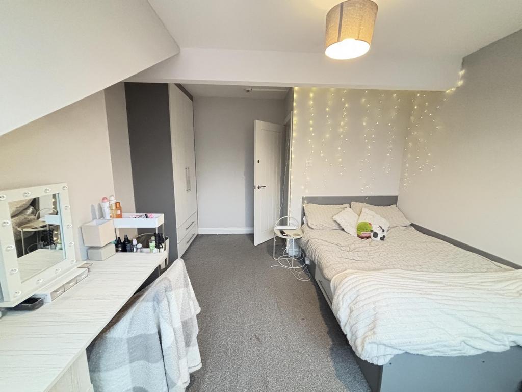 A bright and inviting bedroom featuring a comfo...