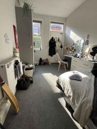 A cozy bedroom brightened by natural sunlight f...