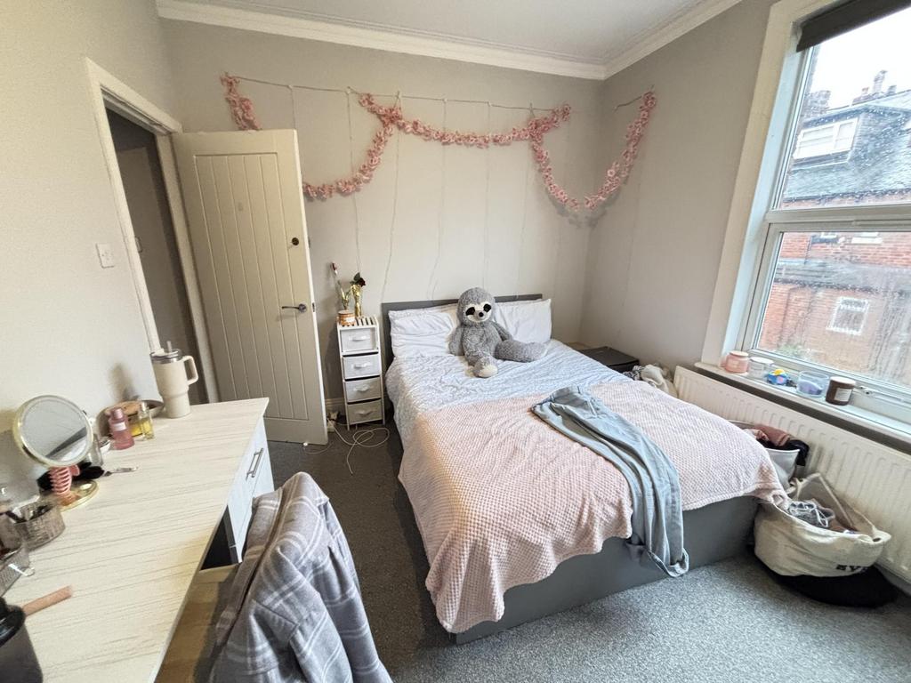 A cozy and well-lit bedroom featuring a comfort...