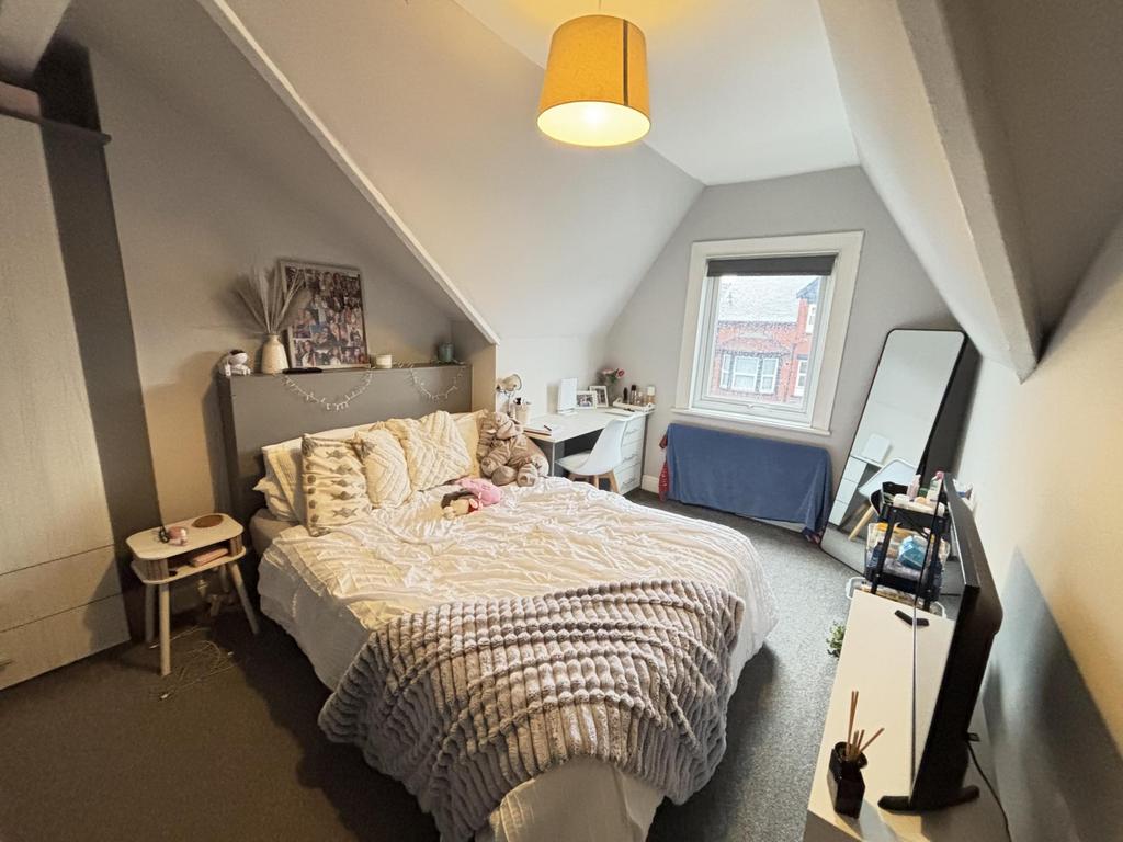 A well-lit, spacious bedroom featuring a double...