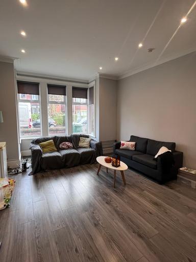 A bright, spacious living room with large windo...