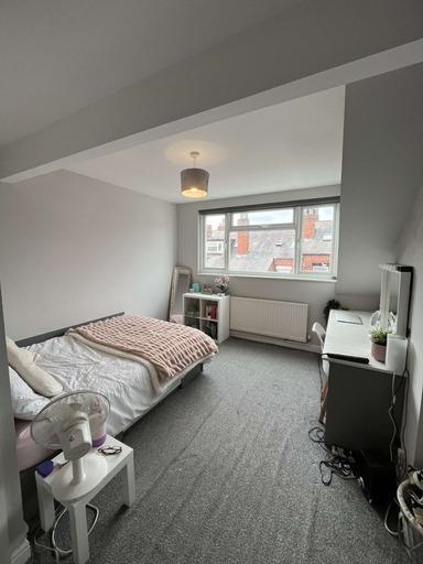 A bright and tidy bedroom featuring a single be...