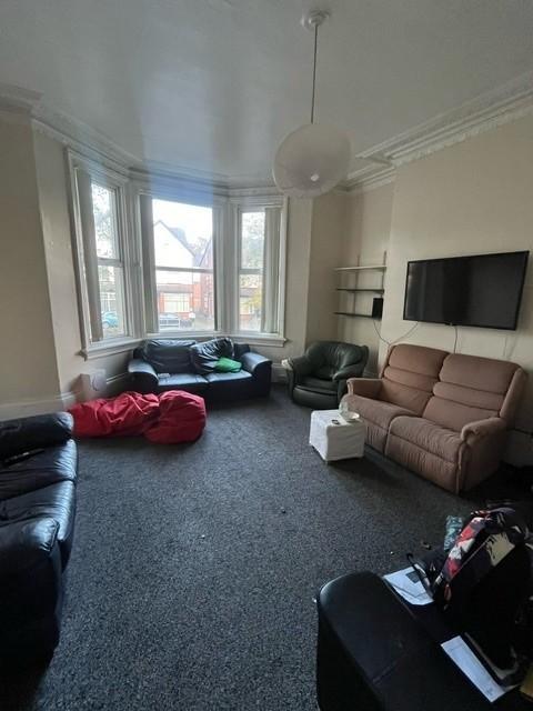 A spacious, bright living room with large windo...