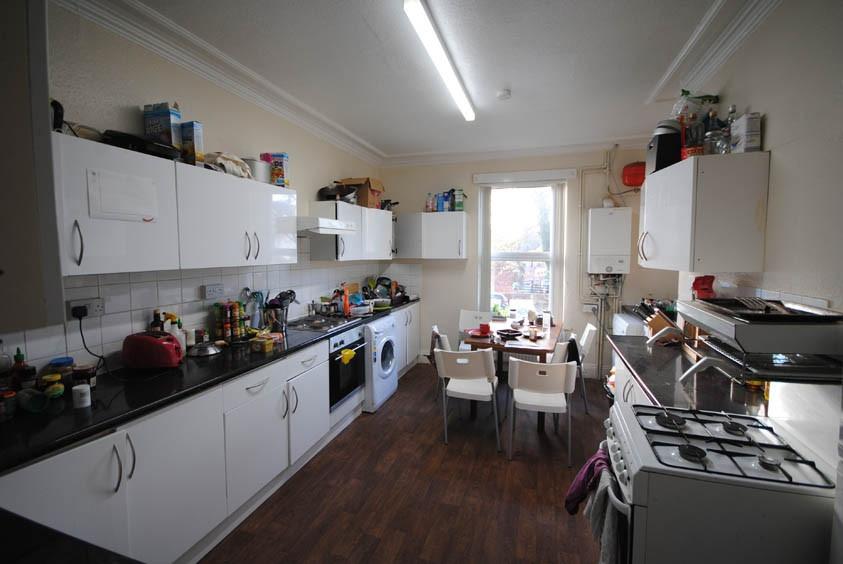 A well-lit kitchen with ample storage cabinets,...