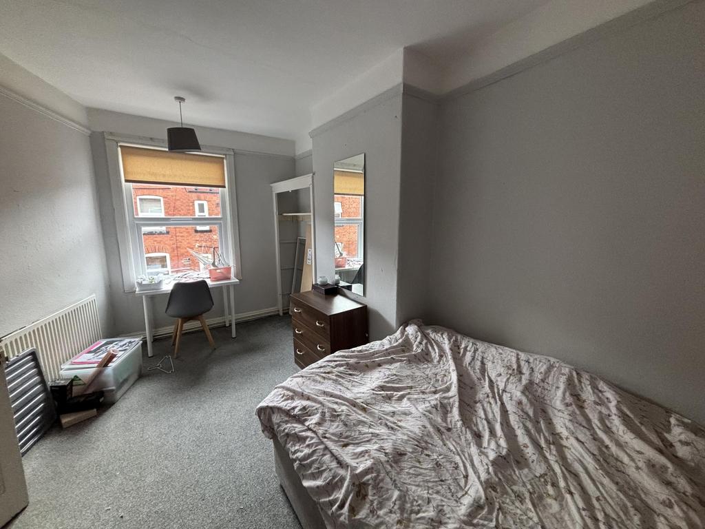 A cozy and well-lit single bedroom featuring a ...