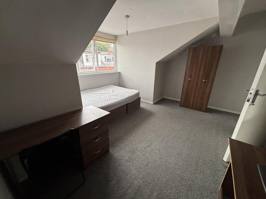 A tidy and well-lit single bedroom with a windo...