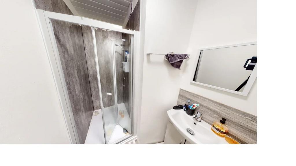 A clean and bright bathroom featuring a large s...