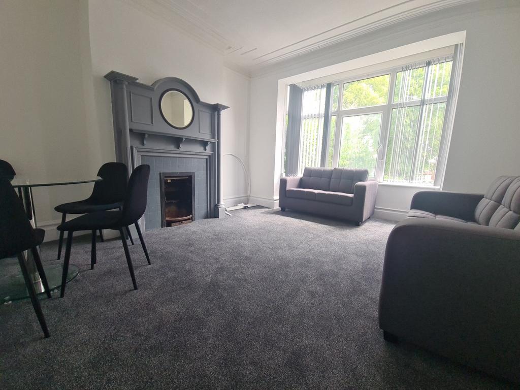A spacious and well-lit living room with large ...