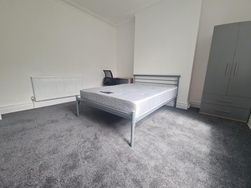 A spacious and bright bedroom featuring a doubl...