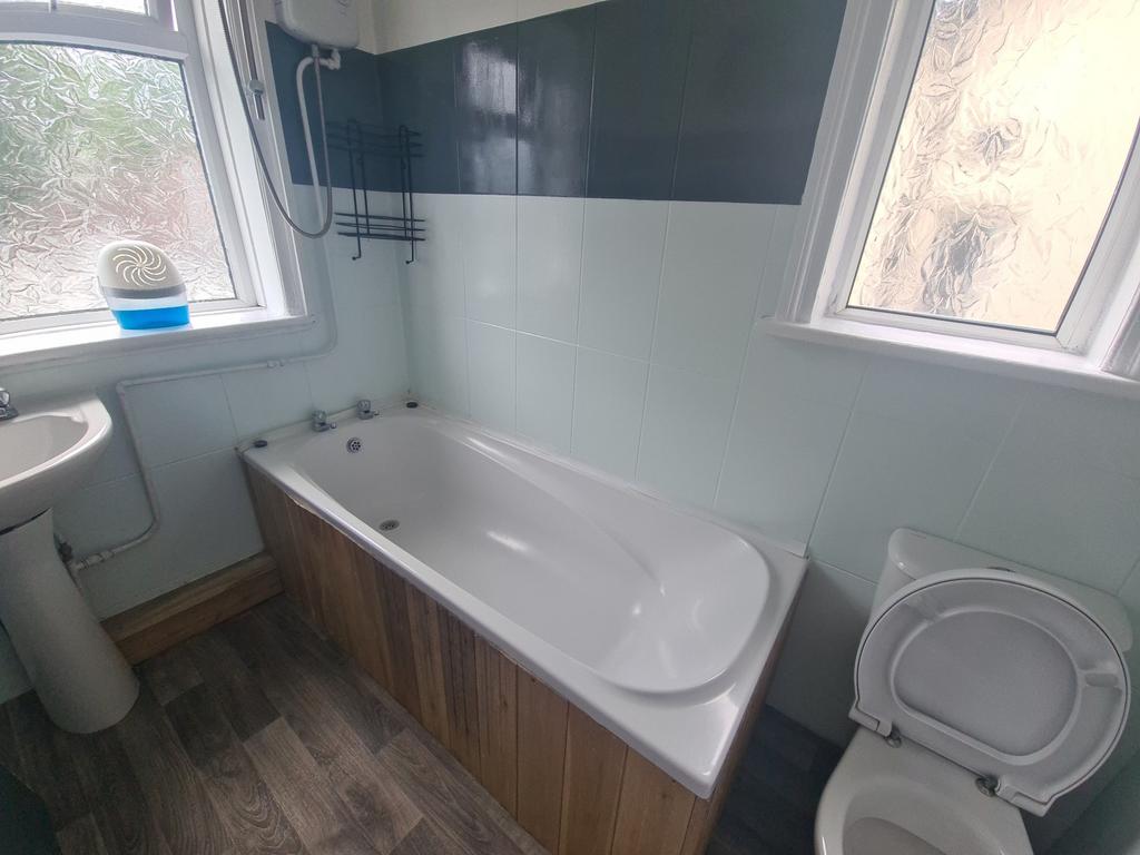 A spacious bathroom featuring a bathtub with cl...